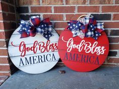 two red and white wood signs with bows on them, one saying god bless america and the other saying godless america