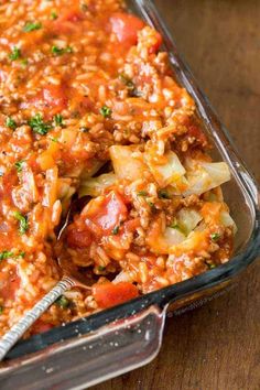 a casserole dish filled with meat, vegetables and sauce on a wooden table