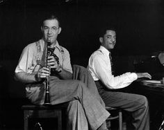 two men sitting next to each other playing musical instruments