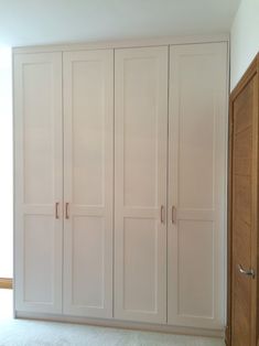 an empty room with white cupboards and carpet