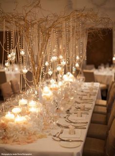 a long table with many candles and flowers on it, all set up for a formal function