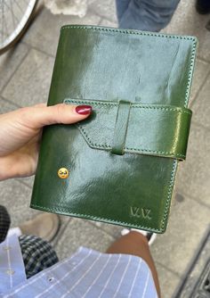 a person holding up a green leather wallet