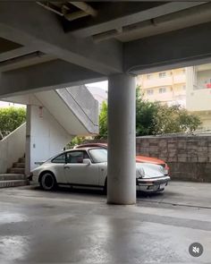 two cars are parked in an empty parking lot next to some stairs and steps that lead up to the second floor