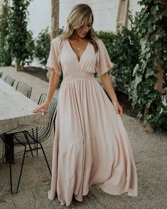 Say hello to our fabulous Delilah Maxi Dress in Blush. This dress is oh so gorgeous and you will not want to miss out! Flowy V-neck Midi Dress For Brunch, V-neck Dress With Smocked Back For Brunch, Fitted V-neck Maxi Dress With Elastic Waistband, V-neck Beach Dress With Elastic Waistband, Pink V-neck Dress With Elastic Waistband, Bohemian V-neck Dress With Smocked Back, Feminine Blush V-neck Maxi Dress, Blush Fitted V-neck Maxi Dress, Flowy V-neck Boho Dress For Day Out