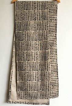 a pair of black and white polka dot patterned towels hanging on a wooden hanger