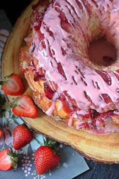 a strawberry bunt cake with icing and strawberries