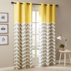 the curtains are yellow and grey with white chevrons on them, in front of a window