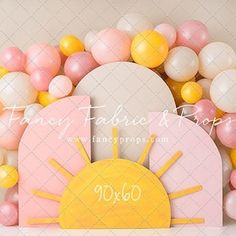 there is a pink and yellow table setting with balloons on the wall in the background