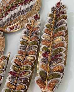 several trays filled with different types of food on top of each other and gold rimmed plates