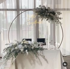 a table with flowers and candles on it in front of a circular sign that says congratulations