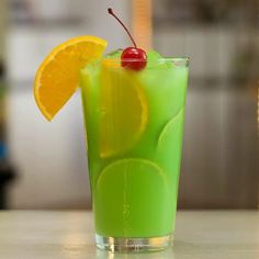 a green drink with orange slices and cherries