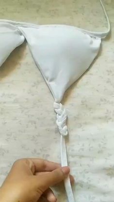 someone is pulling the string off of a white pillow