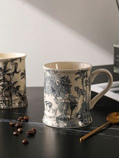 two coffee mugs sitting next to each other on a table