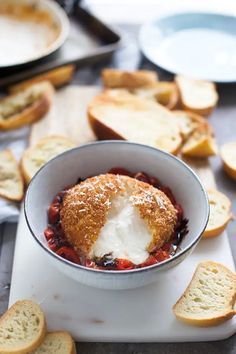 a bowl filled with food next to slices of bread