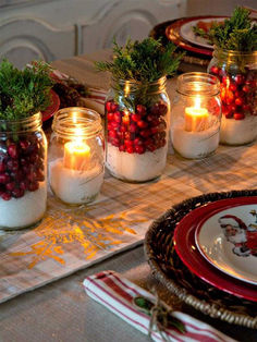 a table topped with mason jars filled with fruit and veggies next to candles