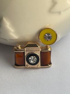 Golden rhinestone camera brooch, arrives in a jewellery bag.  🌟FREE jewellery bag with each brooch🌟 Your brooches can be used for DIY crafting and making brooch bouquets, decorating jewellery boxes, photo frames, hats or anything wedding related.  📮📮Your brooches will be posted within 1-2 working days! 📮📮 The perfect gift for absolutely any occasion!  ❤️Please check out my other brooches!❤️ 📫 Sadly & frustratingly, there can, on the rare occasion, be delays with Royal Mail's own delivery Retro Brooch Lapel Pin For Gifts, Retro Lapel Pin Brooch For Gifts, Retro Brooch Enamel Pin As Gift, Retro Brooch-style Enamel Pin As A Gift, Retro Enamel Brooch Pin For Gifts, Retro Screw Back Jewelry Gift, Acorn Gifts, Acorn Jewelry, Gift Photography