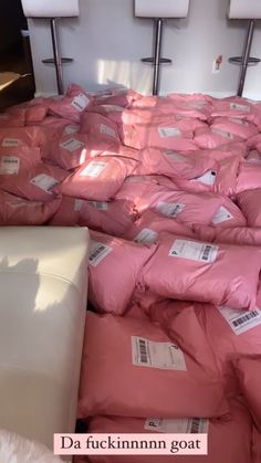 the bed is covered in pink sheets and pillows with price tags on them as well