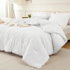 a bed with white sheets and pillows in a room