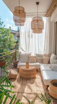 an outdoor living room with wicker furniture and hanging lights above the couches on the balcony