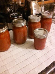 four jars of tomato sauce sitting on a counter