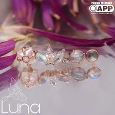 three different types of rings sitting on top of a table next to some purple flowers