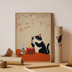 two cats eating out of bowls on a table next to rolled up paper and other items