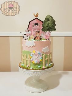 a pink and green cake with farm animals on it