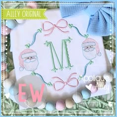 an embroidered monogramm with santa claus on it and some eggs in the grass