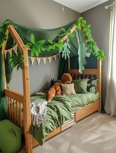 a green canopy bed with stuffed animals on it's sides in a child's bedroom