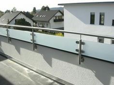 an image of a balcony with railings on the outside and houses in the background