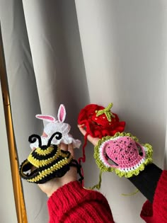 two handmade crocheted hats with animals on them, one is wearing a red sweater