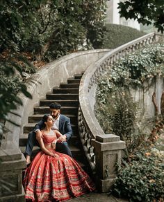 a man and woman are sitting on the stairs in their wedding outfits, looking at each other