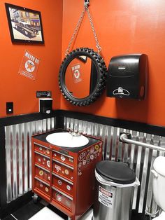 a bathroom with orange walls and black accents