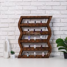 a wooden shelf with bottles on it next to a potted plant and white brick wall