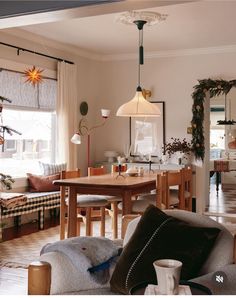 a living room filled with furniture next to a dining room table and chairs in front of a window