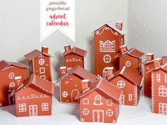 a group of red paper houses sitting on top of a white table next to each other