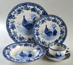 three blue and white plates with roosters on them