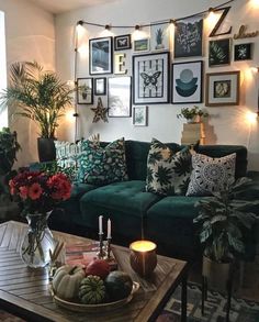 a living room with blue couches and pictures on the wall above them, along with pink flowers in a vase