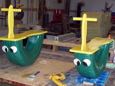 two plastic boats with faces and eyes sitting on top of a wooden table in a shop