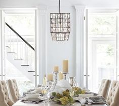 a dining room table with candles and plates on it