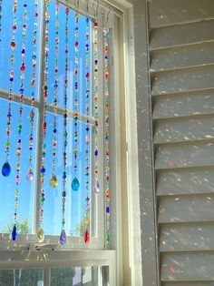 a window with beads hanging from it's side and the sky in the background