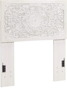 a white fireplace screen with intricate carvings on it