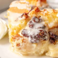 a close up of a pastry on a plate with icing and raisins