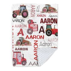 a baby blanket with tractors on it and the words aaron in red, white, and blue