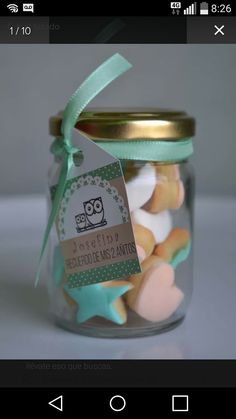 a jar filled with lots of colorful cookies next to a tag on the top of it