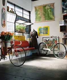 a bicycle parked next to a red bench in front of a wall with pictures on it