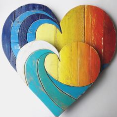 three heart shaped wooden boards with colorful waves painted on the top and bottom, one in the shape of a heart