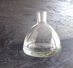 a clear glass bottle sitting on top of a counter next to a black marble wall