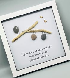 there is a picture frame with some rocks and a stick in it