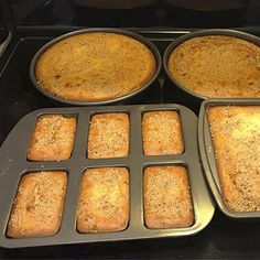 four pans filled with baked goods sitting on top of an oven